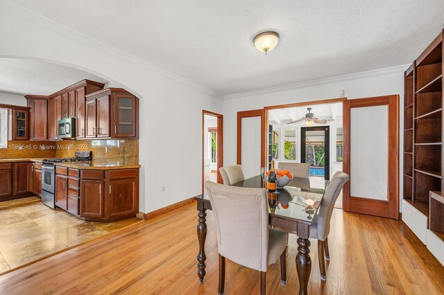 dining room with crown molding and light hardwood / wood-style flooring