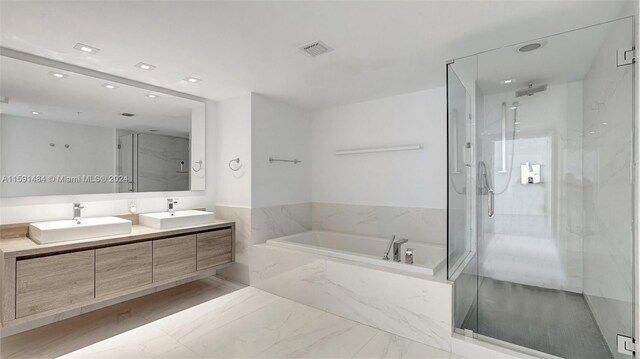 bathroom featuring vanity and separate shower and tub