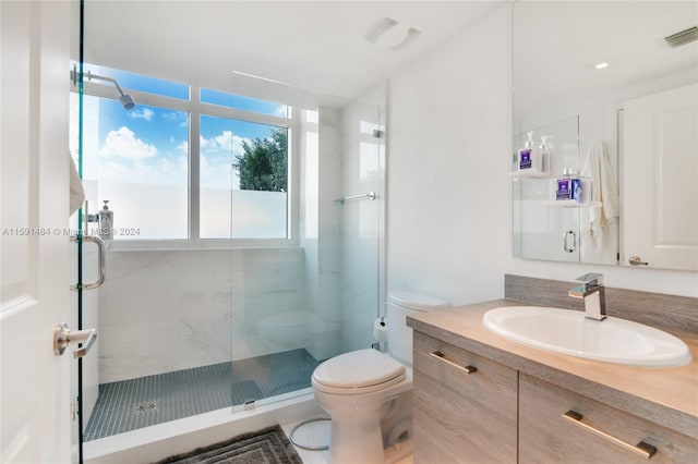 bathroom featuring vanity, toilet, and an enclosed shower