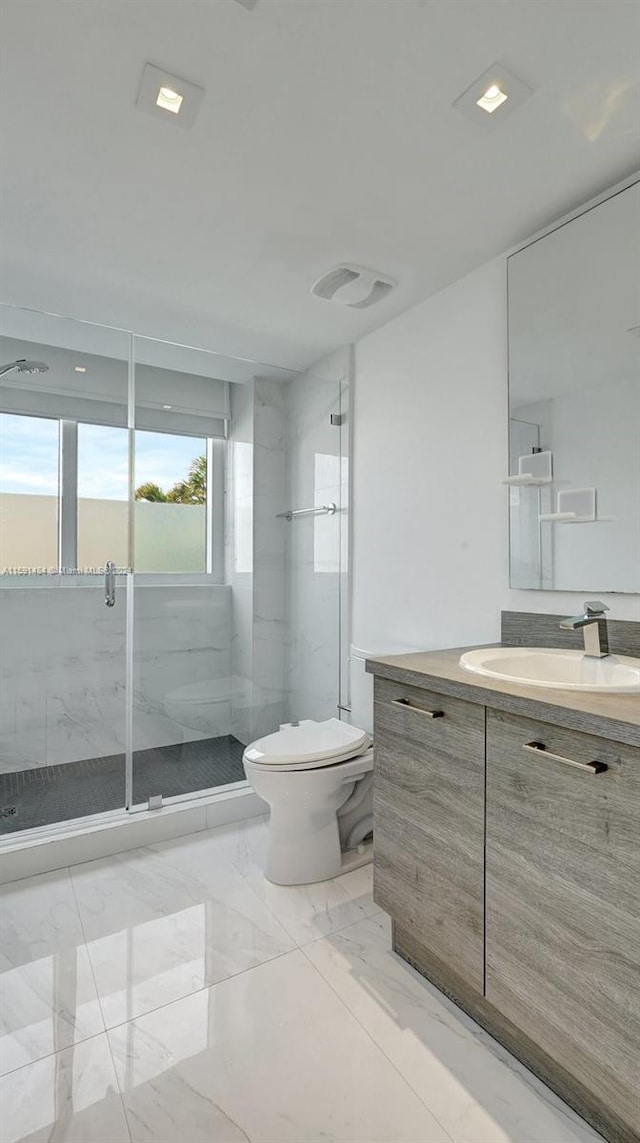 bathroom featuring vanity, toilet, and walk in shower