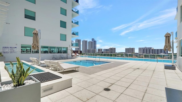 view of pool with a patio and a hot tub