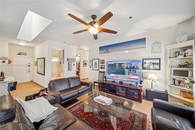 tiled living room with ceiling fan and a skylight