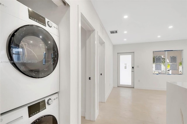 clothes washing area featuring stacked washer and clothes dryer