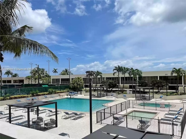 view of pool with a patio area and a hot tub