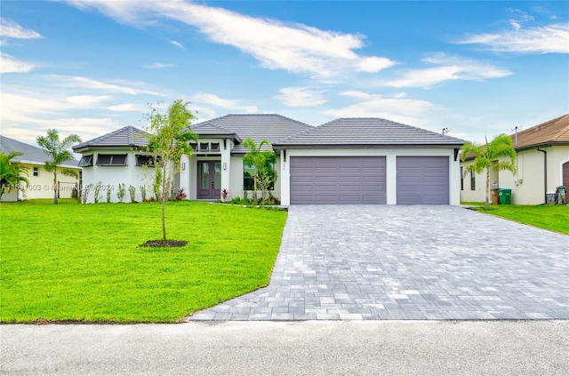 view of front of home with a front yard and a garage