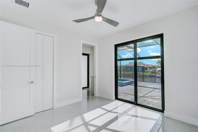 unfurnished bedroom with ceiling fan, light tile patterned floors, a closet, and access to exterior