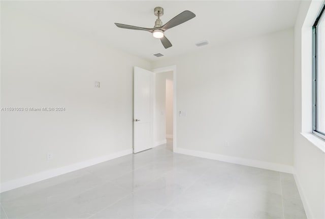 tiled spare room featuring ceiling fan