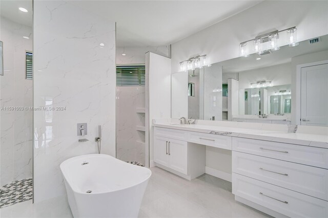 bathroom with vanity, a bath, and tile patterned flooring