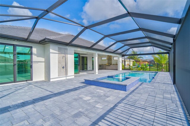 view of swimming pool featuring ceiling fan, glass enclosure, a patio, and an in ground hot tub