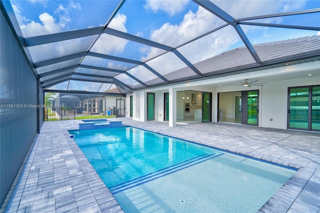 view of pool featuring ceiling fan, glass enclosure, an in ground hot tub, and a patio area