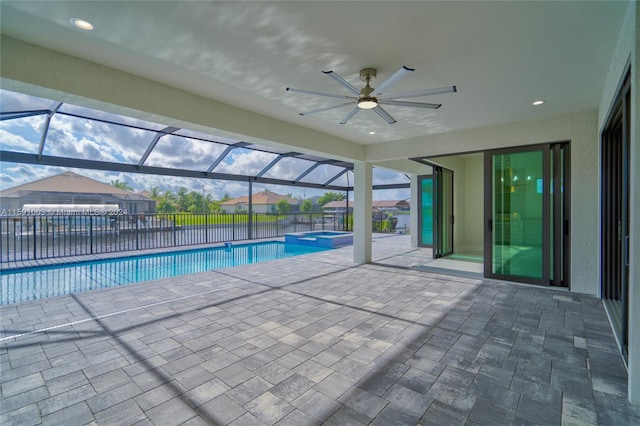 view of pool with glass enclosure, ceiling fan, and a patio