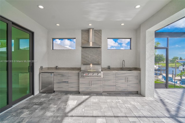 view of patio featuring grilling area, sink, a water view, and an outdoor kitchen