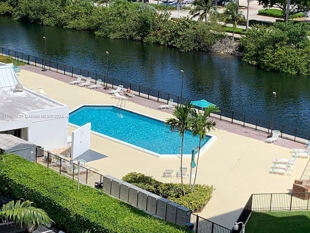 view of swimming pool featuring a water view and a patio