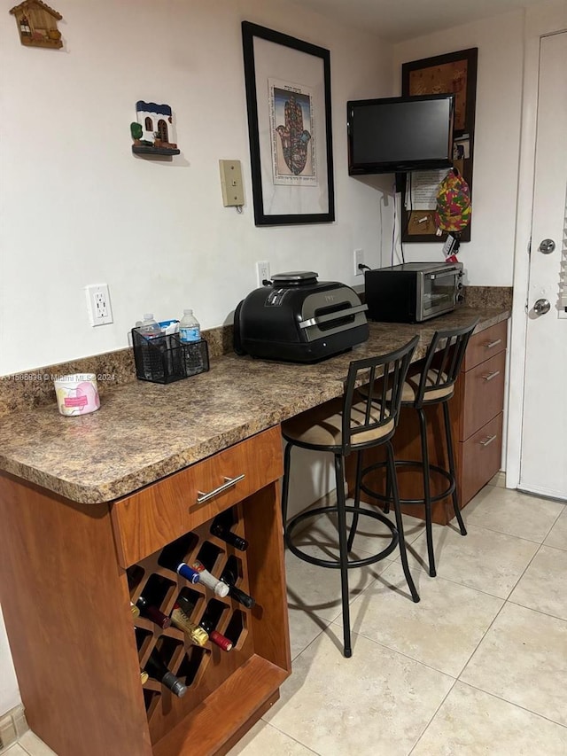 interior space featuring light tile patterned floors and dark stone counters