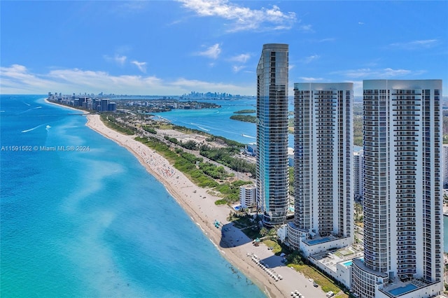 drone / aerial view featuring a beach view and a water view