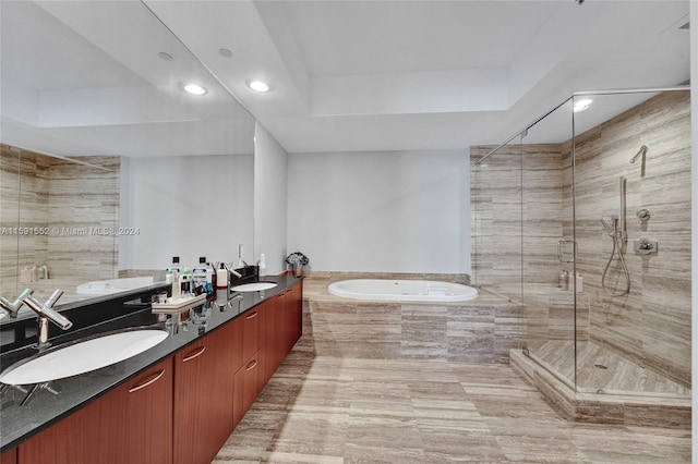 bathroom featuring vanity, a raised ceiling, and independent shower and bath