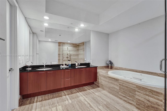 bathroom with vanity, wood-type flooring, and plus walk in shower