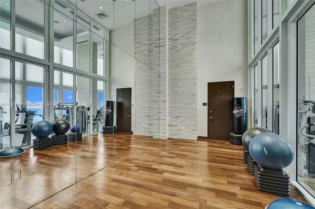 workout area with hardwood / wood-style floors and a high ceiling