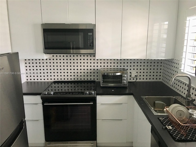 kitchen with stainless steel appliances, sink, and white cabinetry