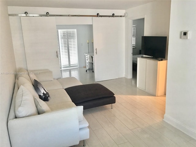 living room featuring a barn door and light hardwood / wood-style flooring