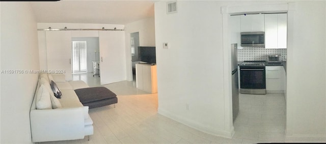 interior space featuring a barn door and light hardwood / wood-style flooring