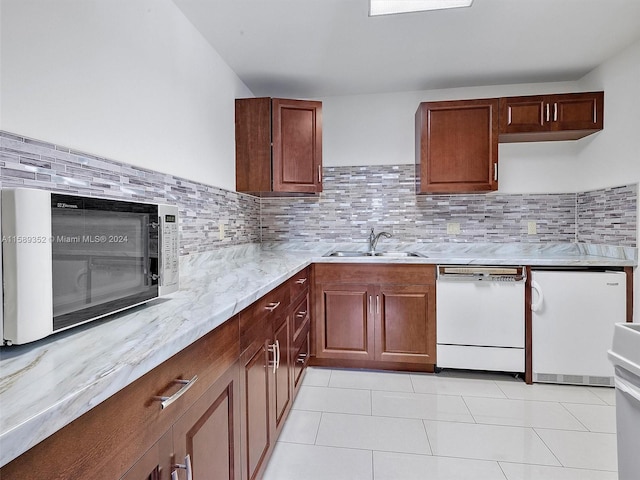 kitchen with sink, white appliances, and backsplash