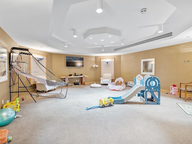 playroom featuring carpet and a tray ceiling