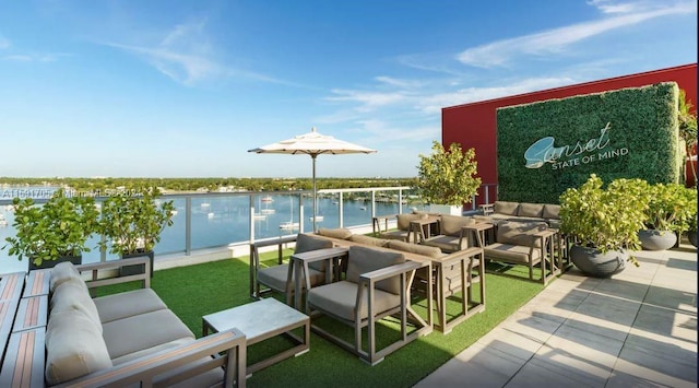 view of terrace with an outdoor living space and a water view