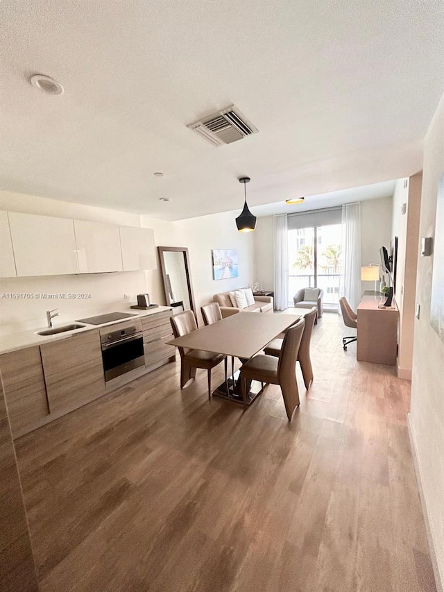 dining area featuring sink, a textured ceiling, and hardwood / wood-style floors