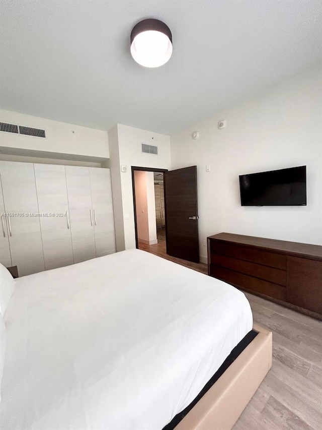 bedroom with a closet and light hardwood / wood-style flooring