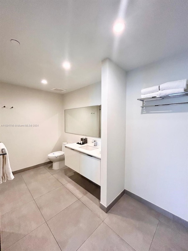 bathroom with vanity, toilet, and tile floors