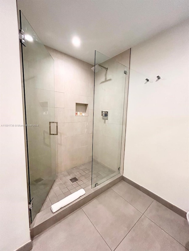 bathroom with tile floors and a shower with door