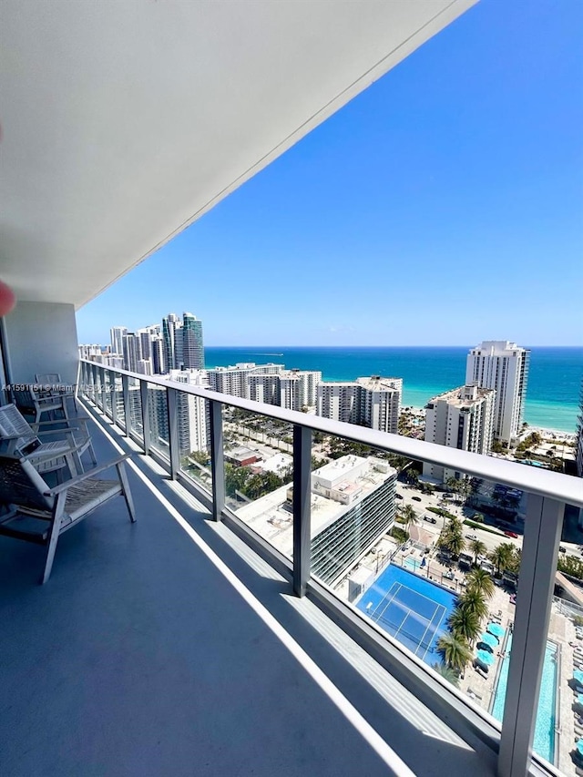 balcony featuring a water view and a city view