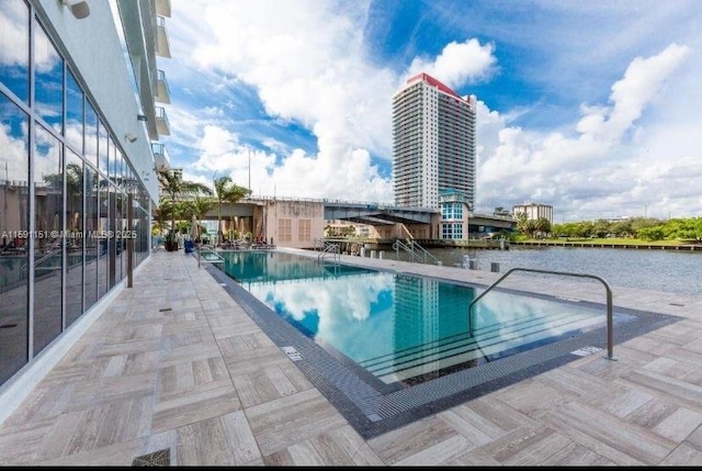 community pool with a patio and a water view