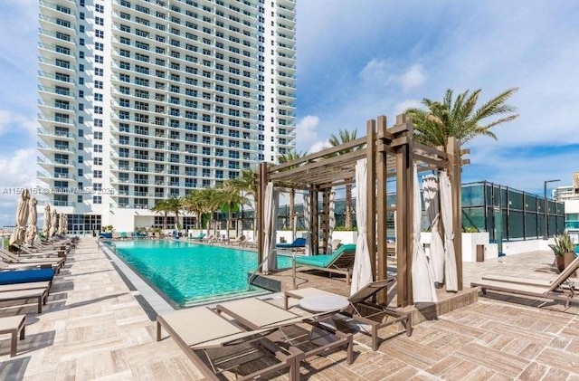 community pool with a patio area, fence, and a pergola