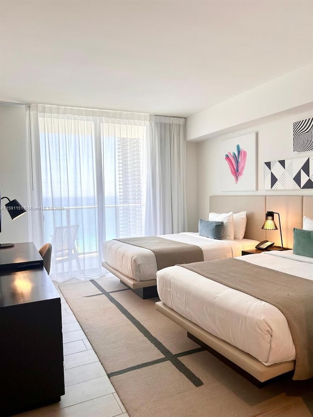 bedroom featuring a wall of windows and wood finished floors