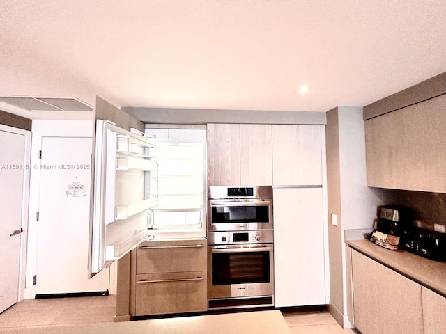 kitchen featuring stainless steel double oven and light countertops