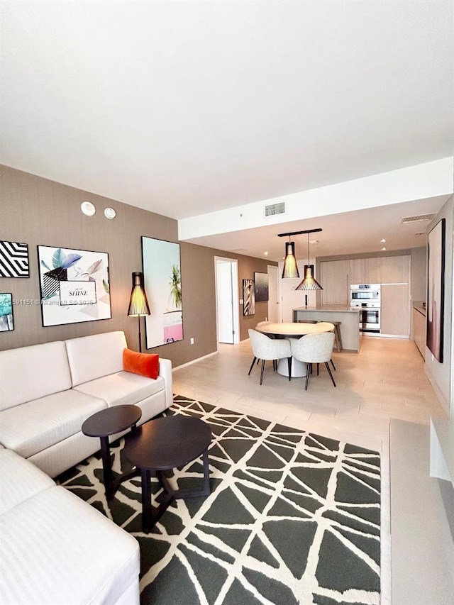 living room with light wood-style floors and visible vents