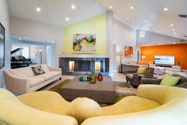 living room with a fireplace and high vaulted ceiling