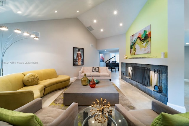 tiled living room featuring a high end fireplace and high vaulted ceiling