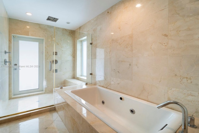 bathroom featuring separate shower and tub and tile walls