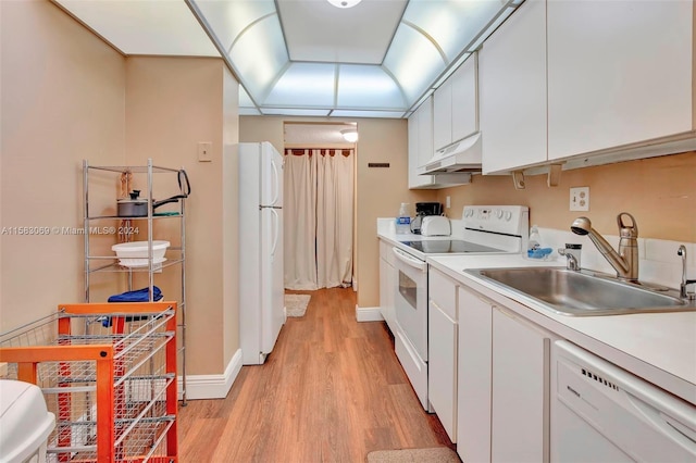 kitchen with light wood-style floors, white appliances, white cabinets, under cabinet range hood, and a sink