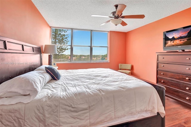 bedroom featuring a textured ceiling, ceiling fan, and hardwood / wood-style floors