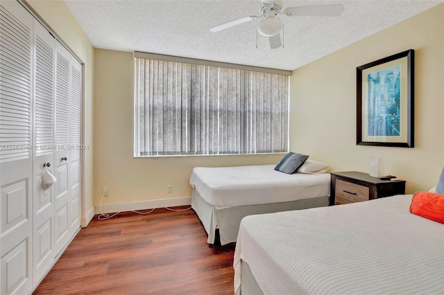 bedroom featuring a closet, ceiling fan, dark hardwood / wood-style flooring, and a textured ceiling