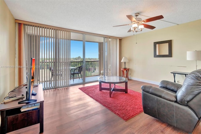 living room with floor to ceiling windows, a textured ceiling, wood-type flooring, and ceiling fan