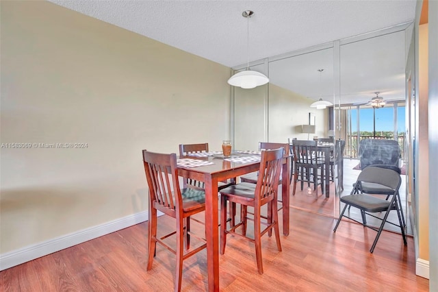 dining space with ceiling fan, a textured ceiling, and hardwood / wood-style flooring