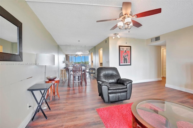 living room featuring hardwood / wood-style floors, ceiling fan, and a textured ceiling