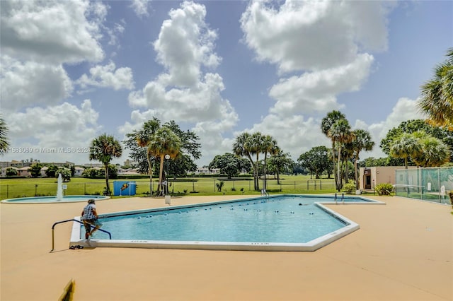 view of swimming pool with a lawn