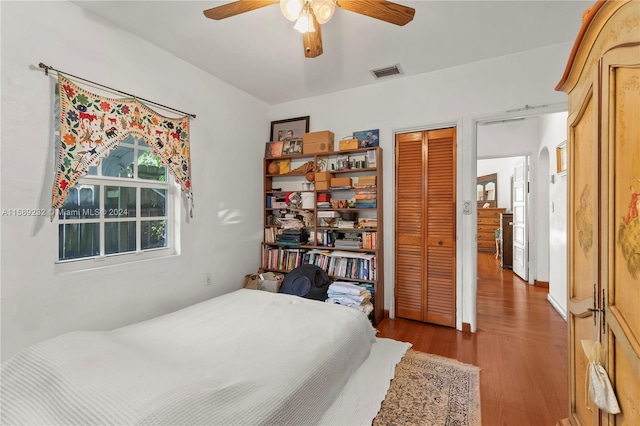 bedroom with hardwood / wood-style flooring, a closet, and ceiling fan