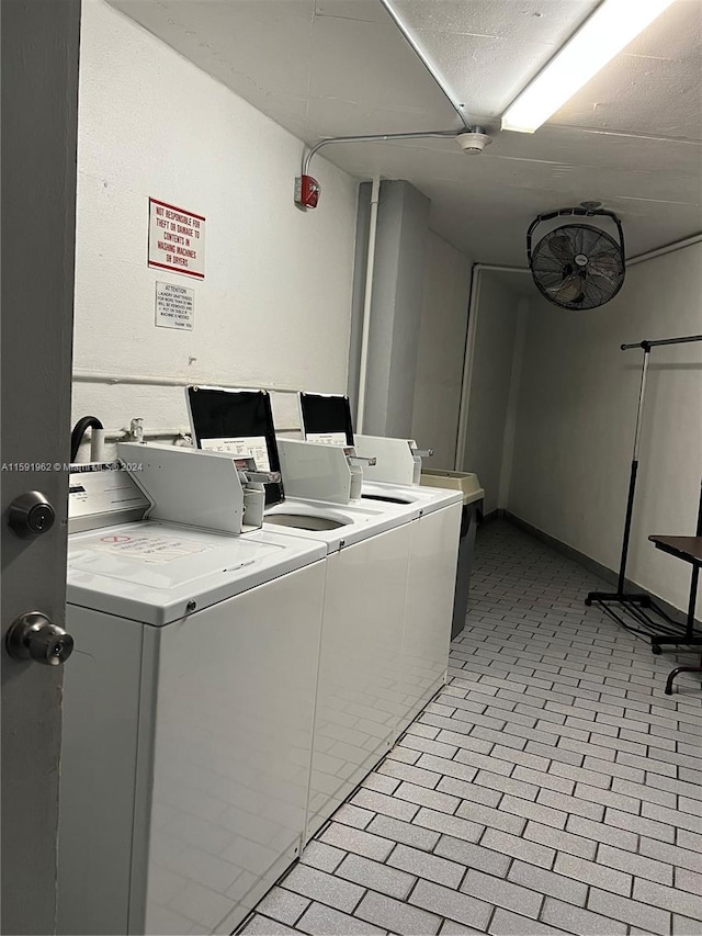 washroom featuring washer and dryer, a textured ceiling, and light tile floors